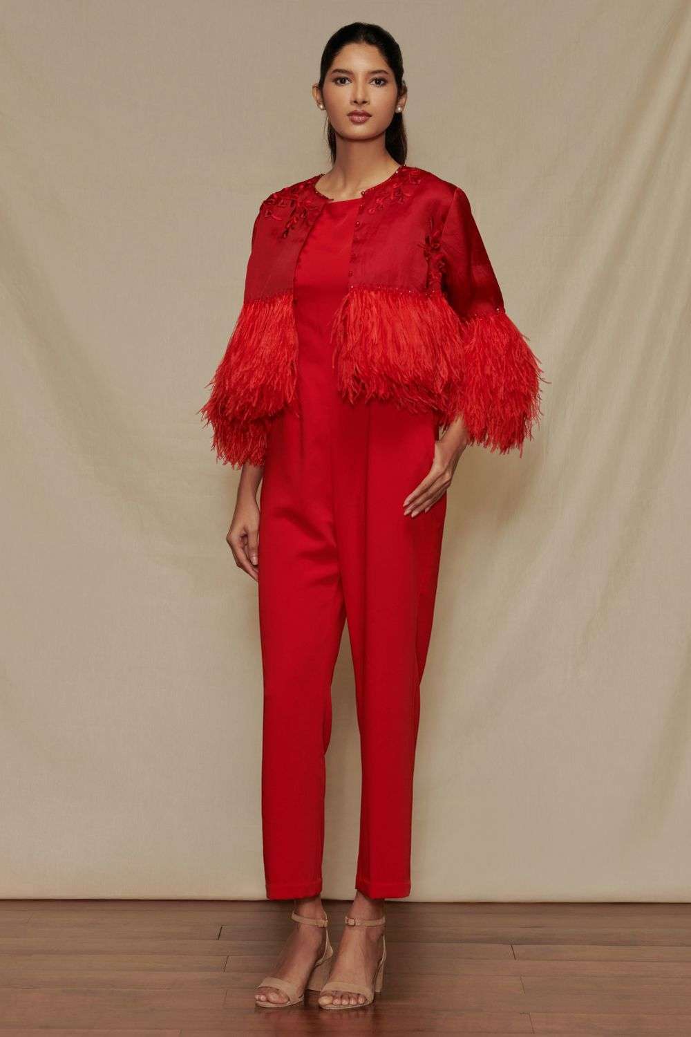 Red jumpsuit with feather capelet